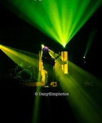 a man on stage with green and yellow lights