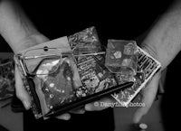 a black and white photo of a person holding a collection of items