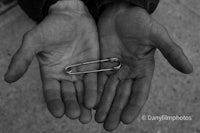 a pair of hands holding a metal pin
