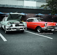 two classic cars parked in a parking lot